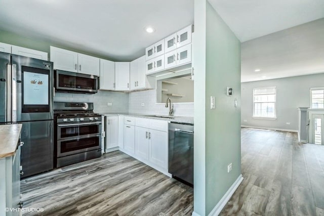 18550 W Sterling Ct W Unit 18550, Grayslake, IL 60030 - kitchen with appliances with stainless steel finishes, white cabinetry, light wood-type flooring, tasteful backsplash, and recessed lighting