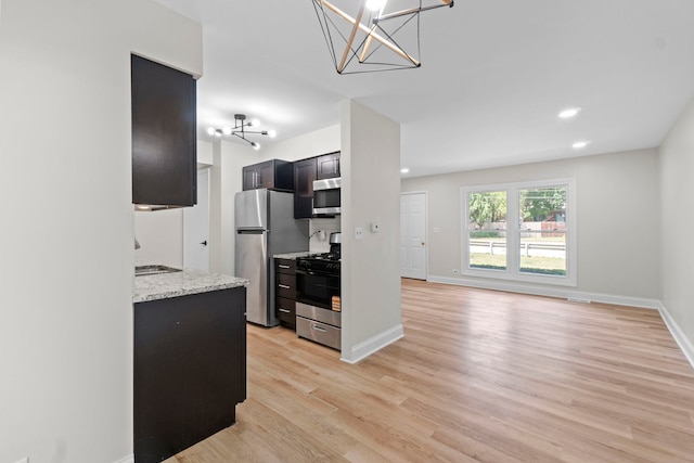 1022 Ashton Ct, Streamwood, IL 60107 - kitchen with stainless steel appliances, light wood-style flooring, a chandelier, recessed lighting, and light stone counters