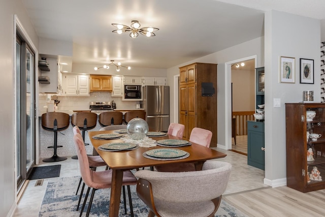 16064 Raintree Rd, Bloomington, IL 61705 - dining area featuring light wood-style flooring and a chandelier