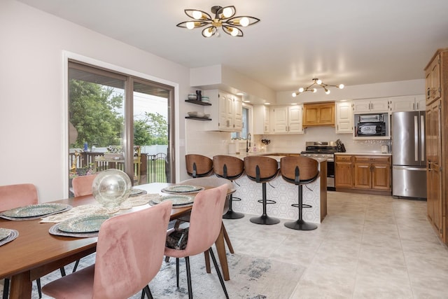 16064 Raintree Rd, Bloomington, IL 61705 - dining space featuring a chandelier and light tile patterned flooring