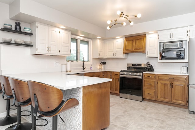 16064 Raintree Rd, Bloomington, IL 61705 - kitchen featuring stainless steel range with gas cooktop, a peninsula, black microwave, open shelves, and a kitchen breakfast bar