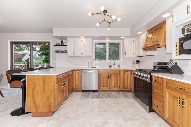 16064 Raintree Rd, Bloomington, IL 61705 - kitchen featuring appliances with stainless steel finishes, a peninsula, premium range hood, a breakfast bar, and a chandelier