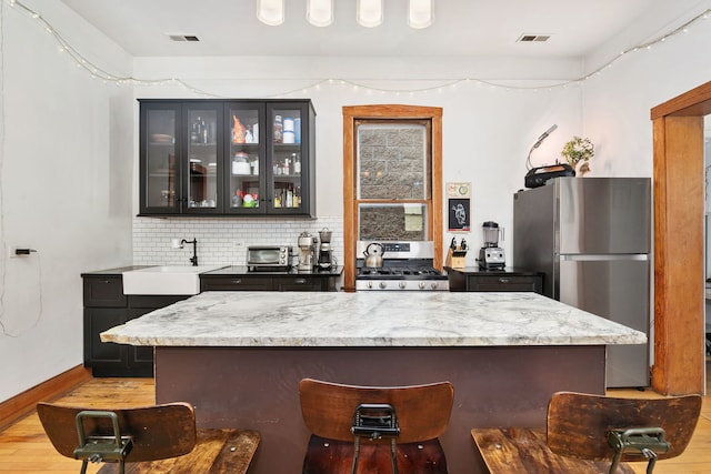 1630 S Fairfield Ave, Chicago, IL 60608 - bar area with stainless steel appliances, light wood-type flooring, and decorative backsplash