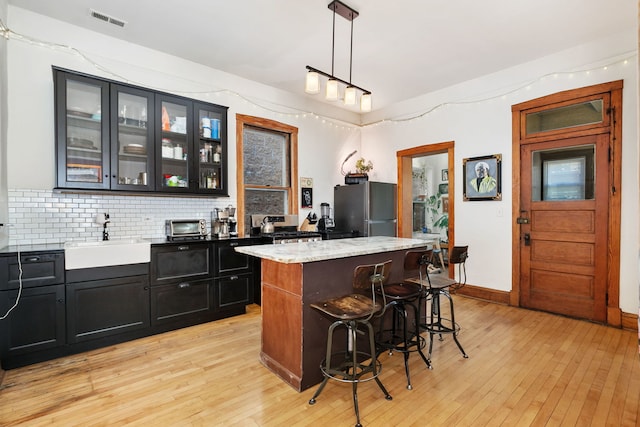 1630 S Fairfield Ave, Chicago, IL 60608 - bar with freestanding refrigerator, light wood-style flooring, backsplash, and decorative light fixtures