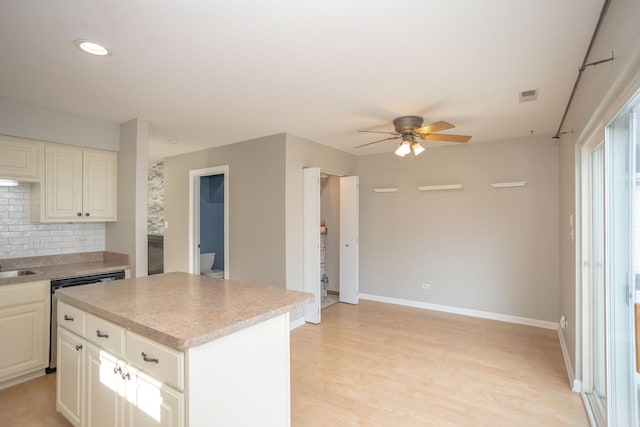 16409 Teton Dr Unit D, Lockport, IL 60441 - kitchen featuring a ceiling fan, dishwasher, light countertops, tasteful backsplash, and a center island