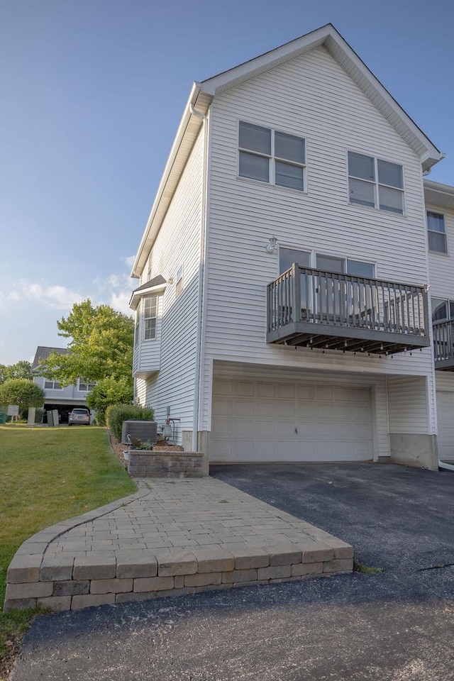 16409 Teton Dr Unit D, Lockport, IL 60441 - back of house with an attached garage, asphalt driveway, and a yard