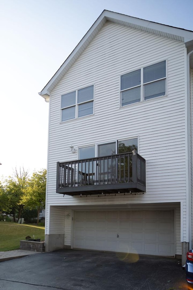 16409 Teton Dr Unit D, Lockport, IL 60441 - rear view of house with an attached garage, a balcony, and driveway