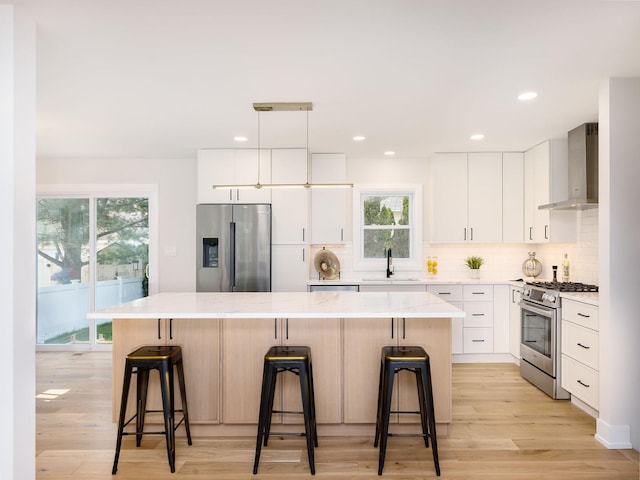 5028 Coyle Ave, Skokie, IL 60077 - kitchen featuring stainless steel appliances, wall chimney range hood, a kitchen island, decorative backsplash, and recessed lighting