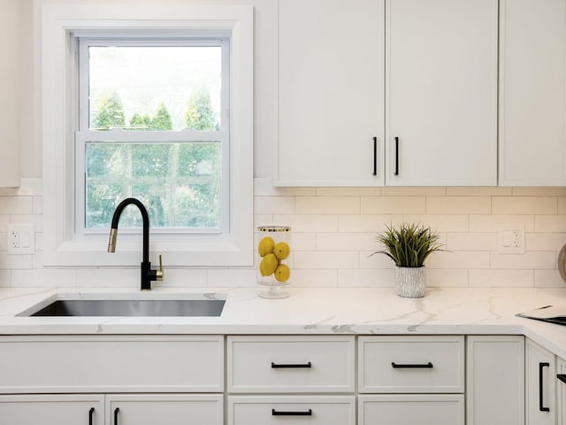 5028 Coyle Ave, Skokie, IL 60077 - kitchen featuring white cabinetry, healthy amount of natural light, backsplash, and light stone counters