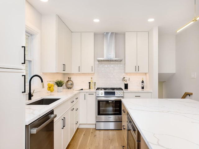 5028 Coyle Ave, Skokie, IL 60077 - kitchen featuring appliances with stainless steel finishes, wall chimney range hood, backsplash, light wood-type flooring, and light stone countertops