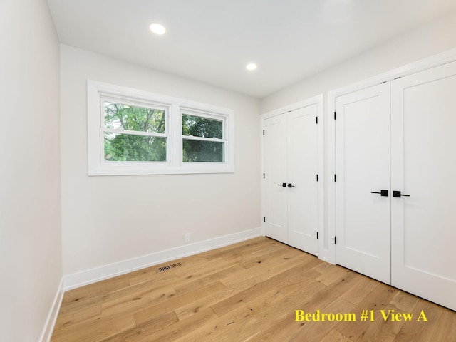 5028 Coyle Ave, Skokie, IL 60077 - unfurnished bedroom with two closets, light wood-type flooring, and recessed lighting