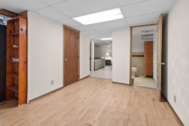 2911 Preston St, Rockford, IL 61102 - spare room with light wood-style flooring, a drop ceiling, and an AC wall unit