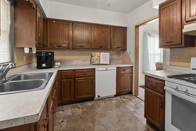 2911 Preston St, Rockford, IL 61102 - kitchen featuring white appliances, light countertops, light floors, under cabinet range hood, and brown cabinetry