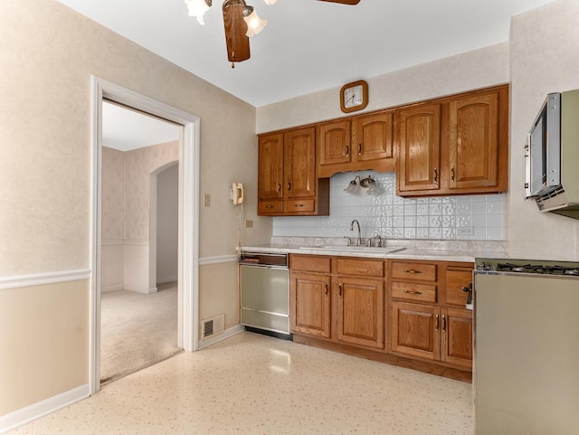 2443 S 4th Ave, North Riverside, IL 60546 - kitchen featuring appliances with stainless steel finishes, a ceiling fan, brown cabinetry, arched walkways, and decorative backsplash