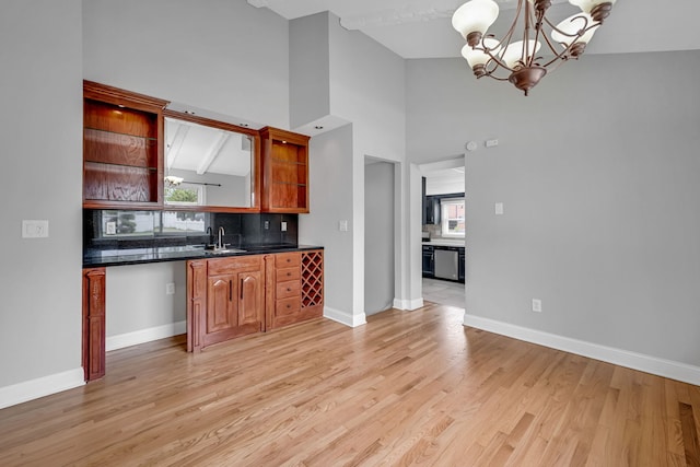 12247 S Avers Ave, Alsip, IL 60803 - kitchen with dark countertops, a chandelier, stainless steel dishwasher, light wood-style floors, and high vaulted ceiling