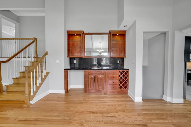 12247 S Avers Ave, Alsip, IL 60803 - kitchen with dark countertops, light wood-style flooring, decorative backsplash, open shelves, and a towering ceiling