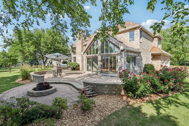 641 Mason Ln, Lake In The Hills, IL 60156 - back of house with a fire pit, a patio area, stone siding, a yard, and a chimney