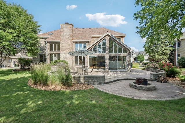 641 Mason Ln, Lake In The Hills, IL 60156 - rear view of house with an outdoor fire pit, a patio, a lawn, a chimney, and a sunroom