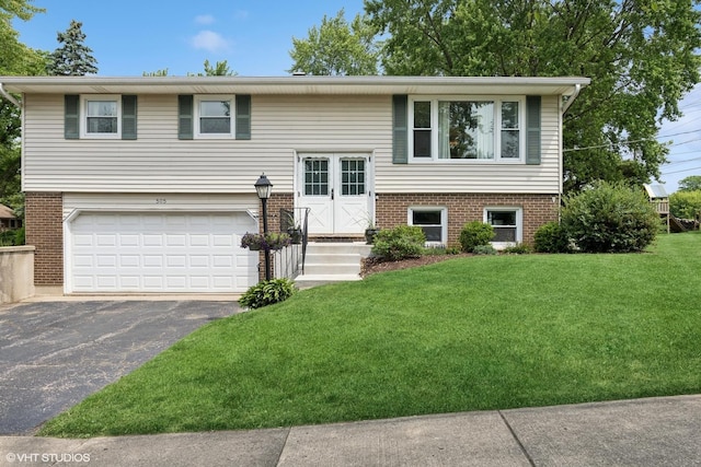 505 Crest Dr, Cary, IL 60013 - bi-level home with asphalt driveway, a garage, a front yard, and brick siding