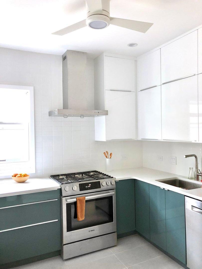 2238 W Winona St, Chicago, IL 60625 - kitchen featuring stainless steel appliances, wall chimney range hood, light countertops, and white cabinets