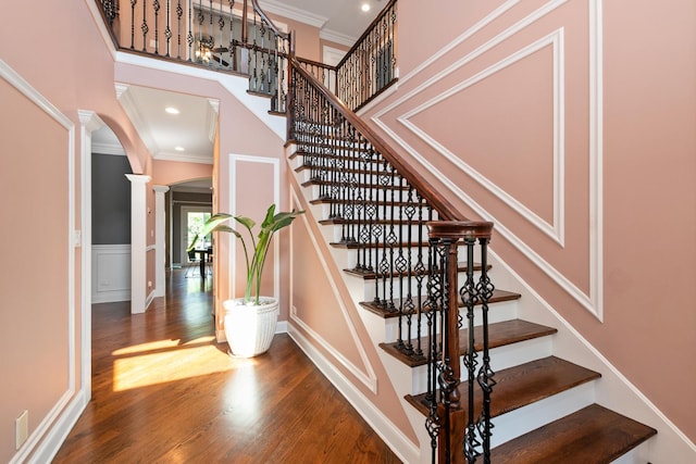 7715 Virginia Ct, Willowbrook, IL 60527 - stairs featuring arched walkways, wood finished floors, crown molding, ornate columns, and a towering ceiling