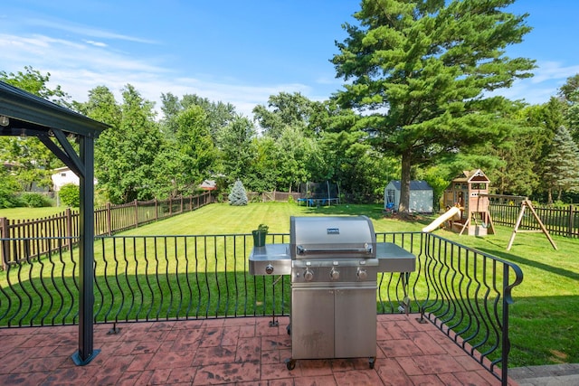 7715 Virginia Ct, Willowbrook, IL 60527 - fenced backyard featuring a trampoline, a playground, a storage shed, area for grilling, and view of wooded area