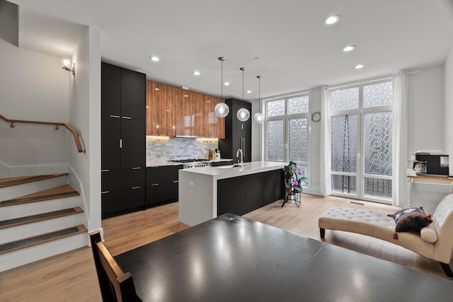6223 S Ellis Ave, Chicago, IL 60637 - kitchen featuring modern cabinets, decorative backsplash, recessed lighting, light wood-style floors, and an island with sink