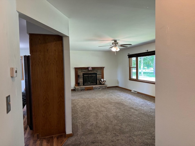 1536 Marberly Dr, Rockford, IL 61103 - unfurnished living room with a ceiling fan, a stone fireplace, and carpet floors