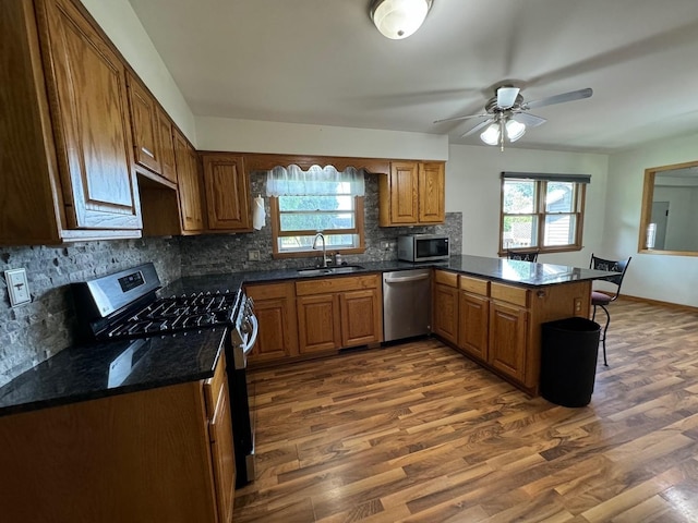 1536 Marberly Dr, Rockford, IL 61103 - kitchen featuring stainless steel appliances, a peninsula, tasteful backsplash, dark wood-type flooring, and a ceiling fan