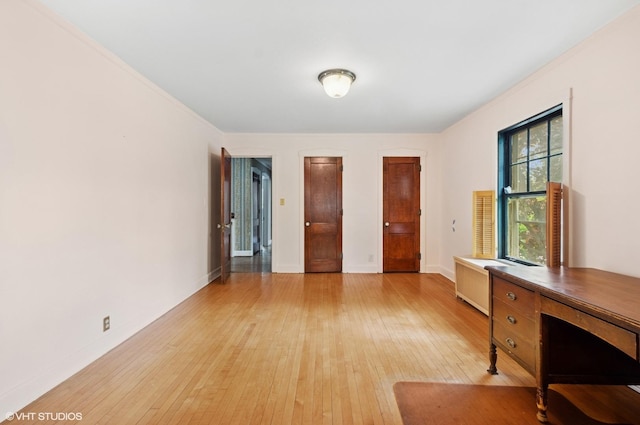 3900 N Keeler Ave, Chicago, IL 60641 - unfurnished bedroom with light wood-type flooring, multiple closets, a desk, and radiator