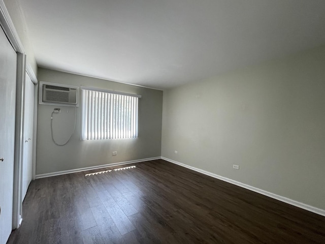1208 Whispering Hills Ct Unit 1A, Naperville, IL 60540 - empty room featuring a wall unit AC and dark wood-type flooring