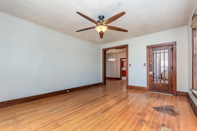 141 E Lincoln St, Seneca, IL 61360 - unfurnished room featuring a ceiling fan, light wood finished floors, and a chandelier