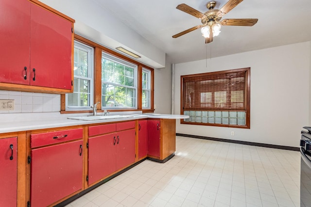 141 E Lincoln St, Seneca, IL 61360 - kitchen with red cabinets, light countertops, ceiling fan, and decorative backsplash