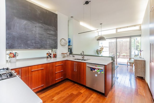 4805 S Langley Ave, Chicago, IL 60615 - kitchen with dishwasher, light countertops, light wood finished floors, a peninsula, and brown cabinetry