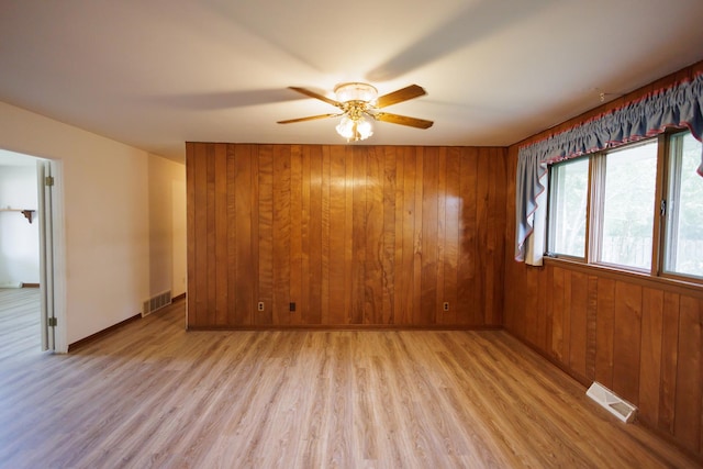 680 S Center Ave, Bradley, IL 60915 - empty room with ceiling fan, light wood finished floors, and wood walls