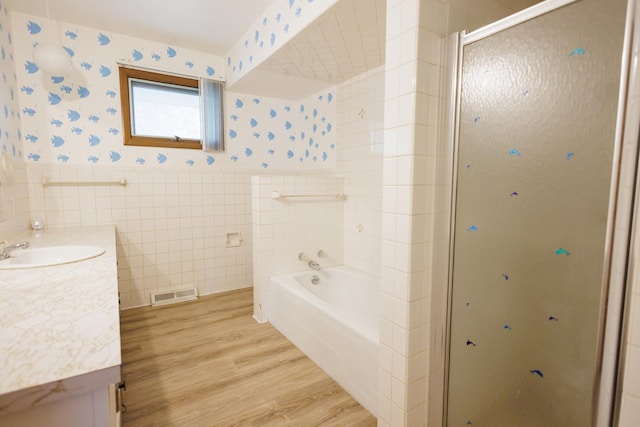 680 S Center Ave, Bradley, IL 60915 - bathroom with vanity, a shower stall, wood finished floors, wallpapered walls, and tile walls