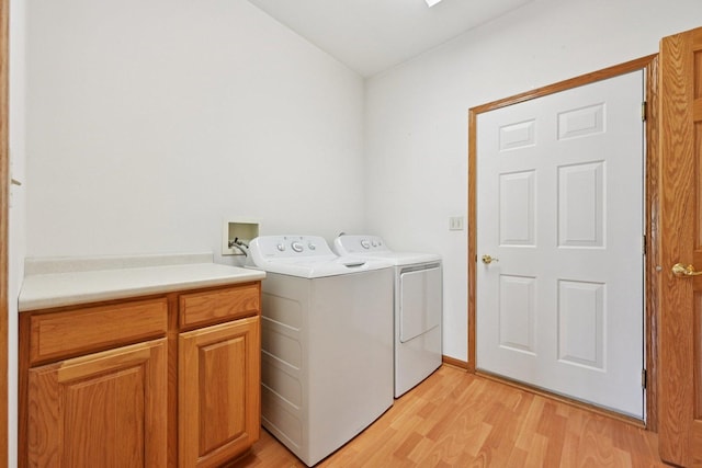 757 Bauman St Unit 0, Marengo, IL 60152 - laundry room with light wood-style flooring, cabinet space, and washing machine and dryer
