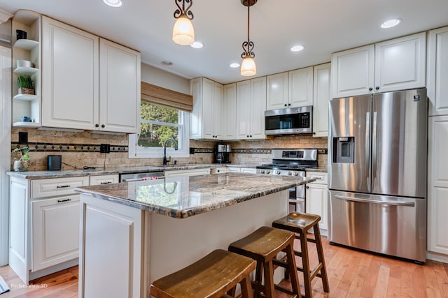 985 W Bauer Rd, Naperville, IL 60563 - kitchen featuring stainless steel appliances, open shelves, a kitchen island, light wood-type flooring, and white cabinetry