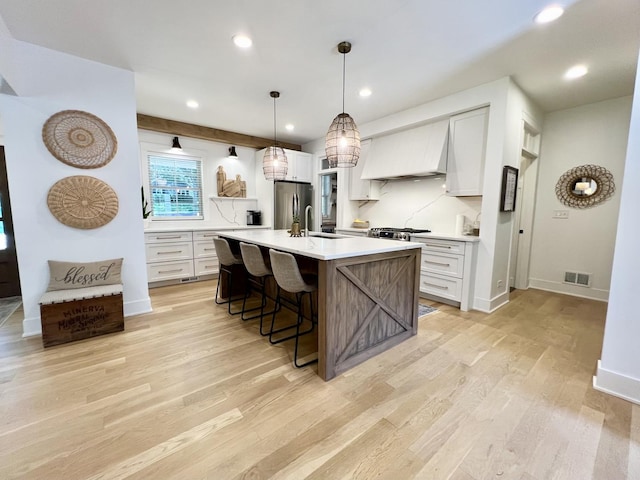 204 Country Commons Rd, Trout Valley, IL 60013 - kitchen featuring freestanding refrigerator, a breakfast bar, light countertops, light wood-style floors, and white cabinetry