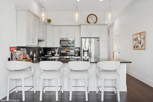2549 N Southport Ave Unit 3, Chicago, IL 60614 - kitchen with appliances with stainless steel finishes, dark countertops, a peninsula, backsplash, and ornamental molding