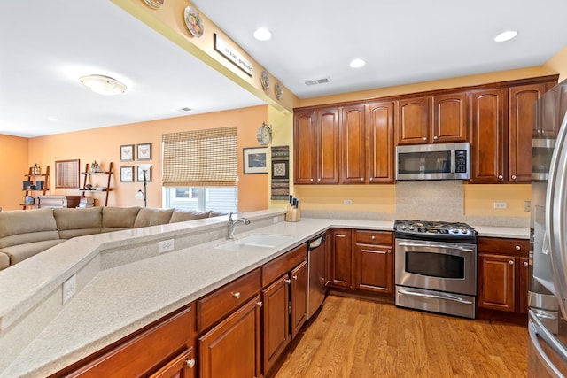 3251 Ravinia Cir, Mundelein, IL 60060 - kitchen featuring appliances with stainless steel finishes, open floor plan, light countertops, light wood-style flooring, and recessed lighting