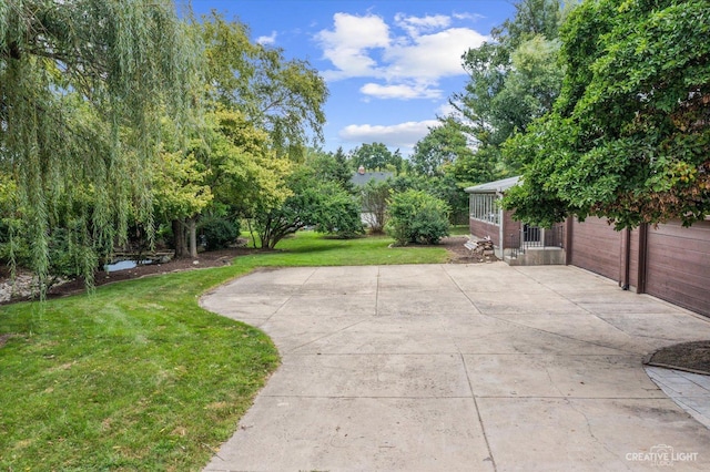 51 Chippewa Dr, Oswego, IL 60543 - view of grassy yard featuring a garage and a patio