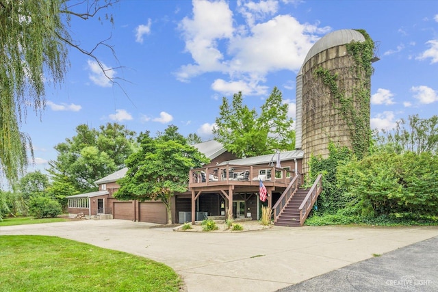 51 Chippewa Dr, Oswego, IL 60543 - view of front of home with a wooden deck, a garage, stairway, concrete driveway, and a chimney