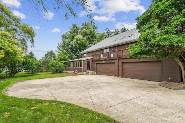 51 Chippewa Dr, Oswego, IL 60543 - view of side of property with concrete driveway, a lawn, a metal roof, a garage, and a balcony