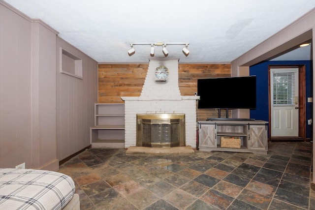 17366 Walden Rd, Hudson, IL 61748 - living area featuring wooden walls, stone tile flooring, and a brick fireplace