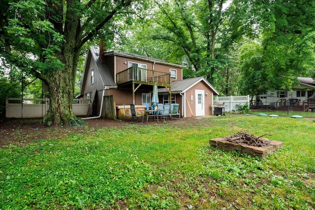 17366 Walden Rd, Hudson, IL 61748 - rear view of property with a fire pit, a fenced backyard, a metal roof, a chimney, and a wooden deck