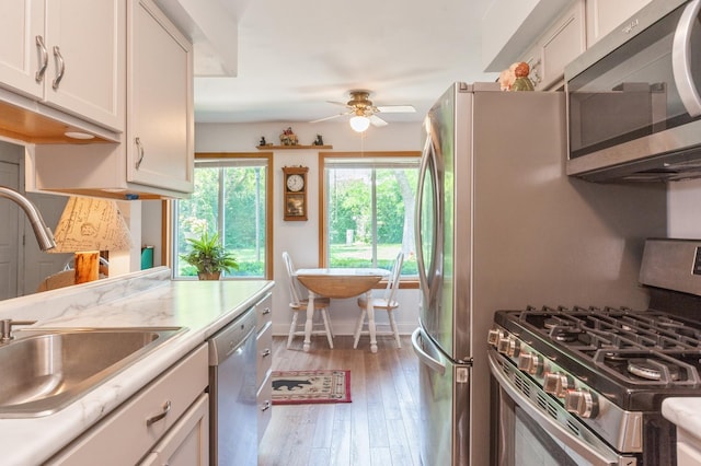 1232 Cove Dr, Prospect Heights, IL 60070 - kitchen with appliances with stainless steel finishes, ceiling fan, light countertops, white cabinetry, and hardwood / wood-style floors