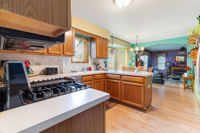 255 Ironbark Ct, Bolingbrook, IL 60440 - kitchen featuring a peninsula, light countertops, light wood-type flooring, backsplash, and open floor plan
