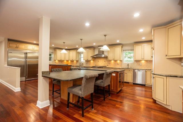 2900 W Birchwood Ave, Chicago, IL 60645 - kitchen featuring stainless steel appliances, cream cabinets, wall chimney range hood, and recessed lighting