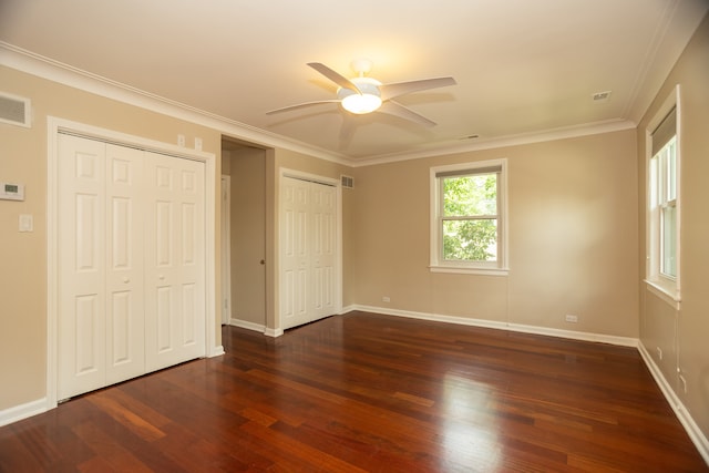 2900 W Birchwood Ave, Chicago, IL 60645 - unfurnished bedroom with multiple closets, dark wood-style flooring, ornamental molding, and a ceiling fan